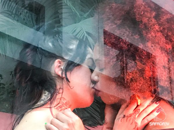 Duas atrizes de Sobre Peles se beijam, em imagem de dupla exposição