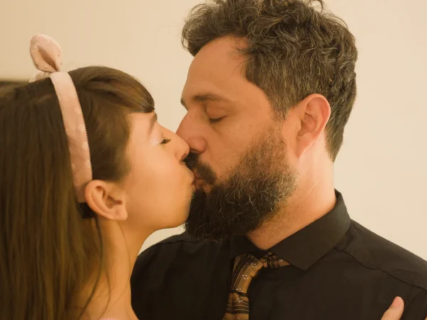 Casal se beija em close, ela de tiara de orelhinhas