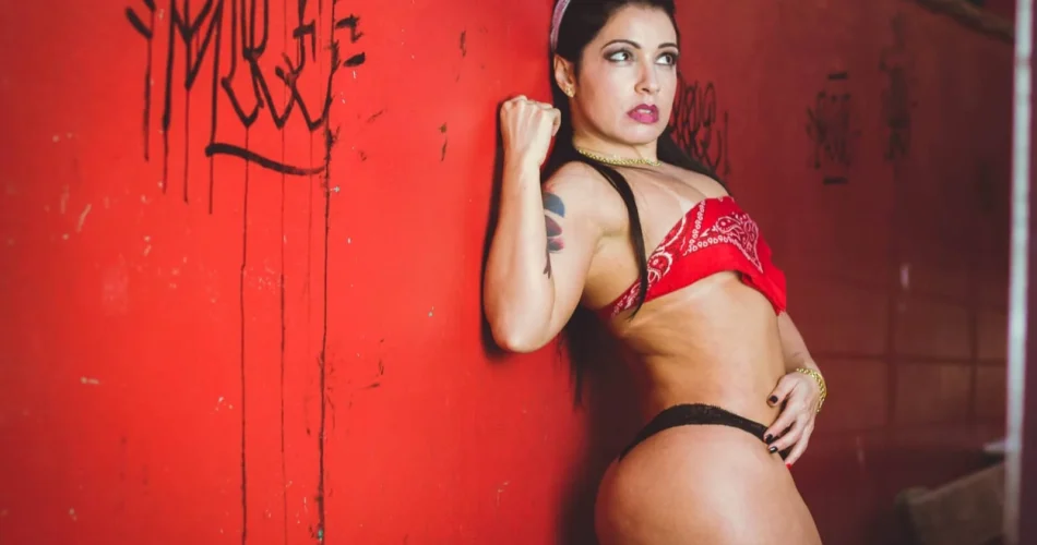 Mônica Santhiago de biquíni vermelho, de frente, numa parede vermelha